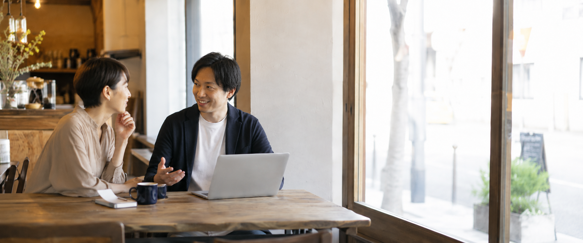 お店の方と一緒に広告の出し方を相談する風景