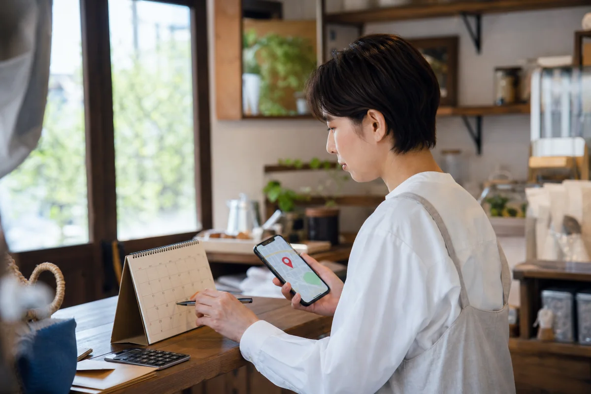 営業時間と場所の情報を確認しながらホームページ準備をする店主