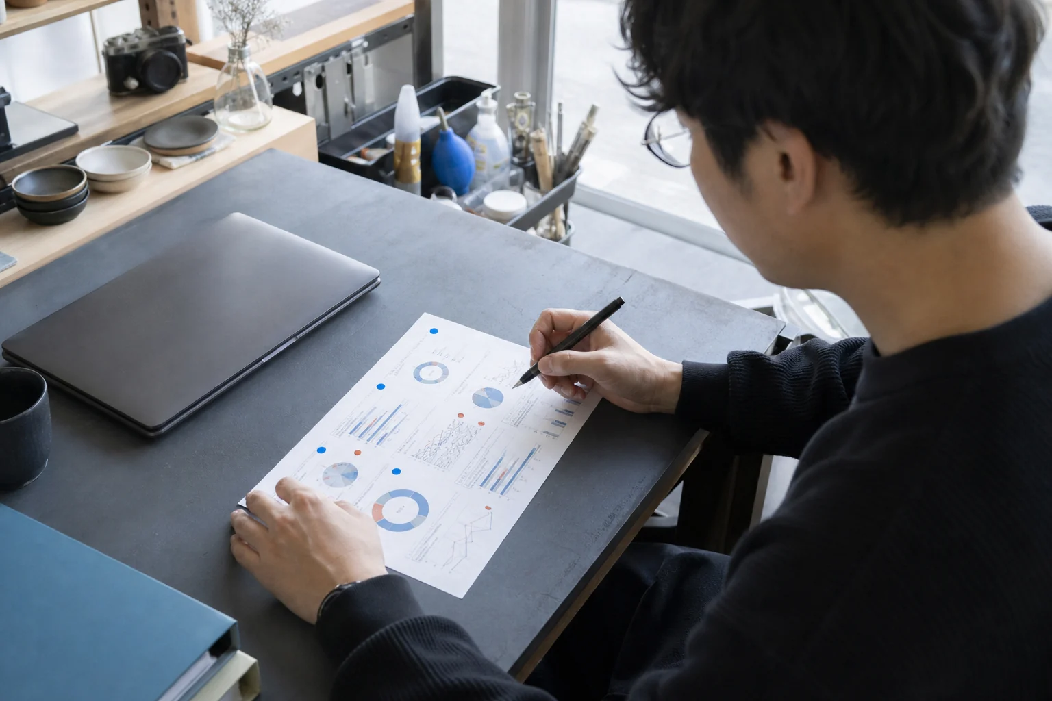 紙のレポートを見ながら広告の数字を確認する事業者